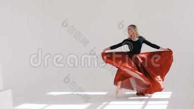 年轻漂亮的芭蕾舞演员在白色背景上跳舞。 红裙<strong>飘飘</strong>.. 巴列丽娜项目。